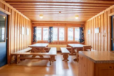 a room with benches and tables in a wooden cabin at Voss Mountain Lodge in Mjølfjell