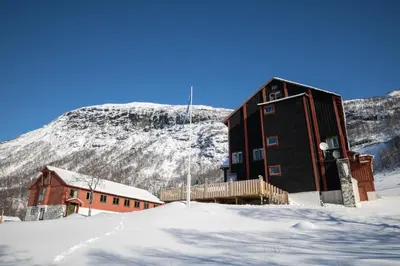 a building in the snow in front of a mountain at Voss Mountain Lodge in Mjølfjell