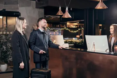a man and a woman standing at a counter at Bergstadens Hotel & Spa in Røros