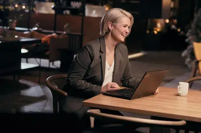 a woman sitting at a table with a laptop at Bergstadens Hotel & Spa in Røros