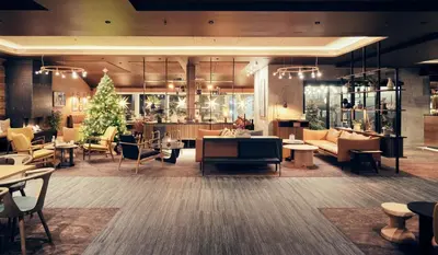 a lobby with a christmas tree and tables and chairs at Bergstadens Hotel & Spa in Røros