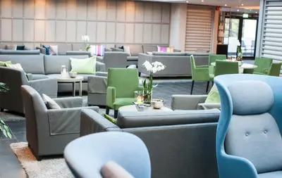 a waiting room with couches and chairs and tables at Hurdalsjøen Hotel & Spa in Hurdal