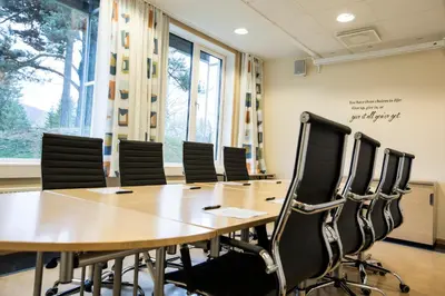 a conference room with a wooden table and chairs at Hurdalsjøen Hotel & Spa in Hurdal