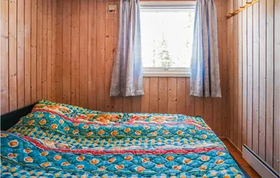 a bed with a quilt on it in a room with a window at Amazing Home In Sjusjøen With Wifi in Sjusjøen