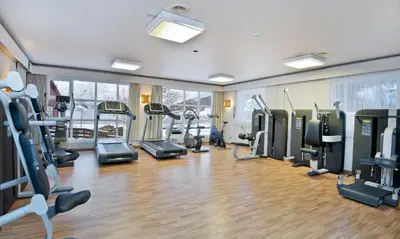 a gym with treadmills and ellipticals in a room at Grand Hotel Skei - Unike Hoteller in Skei