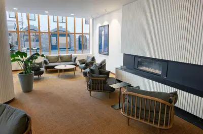 a living room with couches and a fireplace at Hotel Noreg in Ålesund