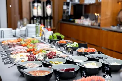 a buffet line with bowls of food on a table at Hotel Noreg in Ålesund