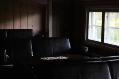 a living room with two leather chairs and a window at Smedsgården Hotel in Nesbyen