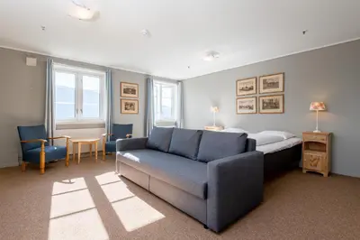 a living room with a bed and a couch and a bed at Nermo Hotel & Apartments in Hafjell