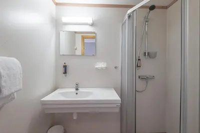 a white bathroom with a sink and a mirror at Nermo Hotel & Apartments in Hafjell