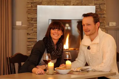 a man and a woman sitting at a table with candles at Nermo Hotel & Apartments in Hafjell