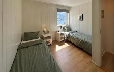 a bedroom with two beds and a window at 5 Bedroom Awesome Home In Etne in Erve