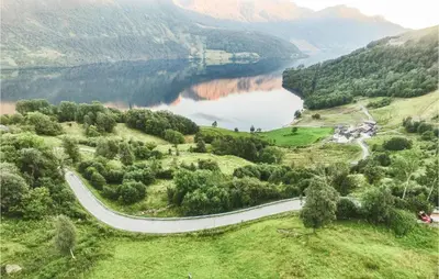 a winding road in a valley with a lake at 5 Bedroom Awesome Home In Etne in Erve