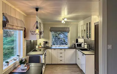 a kitchen with white cabinets and a window at 5 Bedroom Awesome Home In Etne in Erve