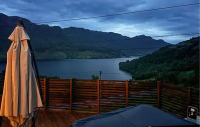 an umbrella on a deck with a view of a lake at 5 Bedroom Awesome Home In Etne in Erve