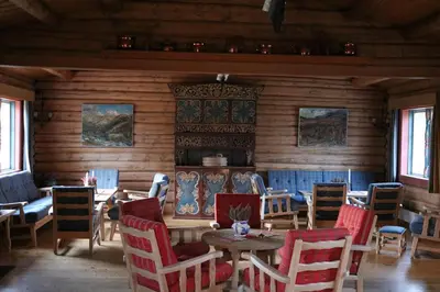 a dining room with wooden walls and tables and chairs at Øigardseter Fjellstue in Høvringen