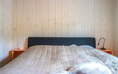 a bedroom with a bed with two lamps on two tables at Nice Home In Lillehammer With Sauna in Lillehammer