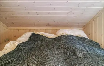 a bed in a room with a wooden ceiling at Nice Home In Lillehammer With Sauna in Lillehammer