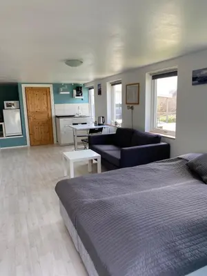 a bedroom with a bed and a living room at 1-rom Apartment Sommer - Frøya in Sætra