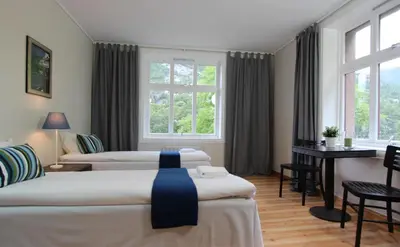 a hotel room with three beds and a window at Slottet Apartments in Tysso