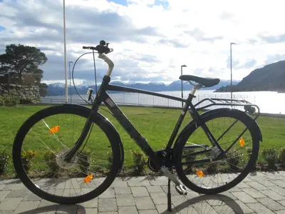 a bike parked on a sidewalk near a body of water at Lavik Fjord Hotel & Apartments in Lavik