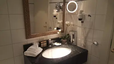 a bathroom with a sink and a mirror at Angvik Gamle Handelssted - by Classic Norway Hotels in Angvik