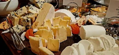 a bunch of cheeses and other foods on a table at Angvik Gamle Handelssted - by Classic Norway Hotels in Angvik