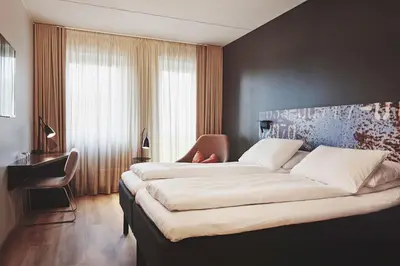 a bedroom with a large bed and a chair at Stord Hotel in Stord