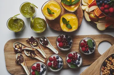 a table with spoons and bowls of fruit and vegetables at Stord Hotel in Stord