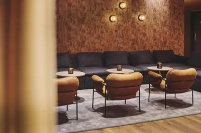 a living room with a couch and tables and chairs at Stord Hotel in Stord