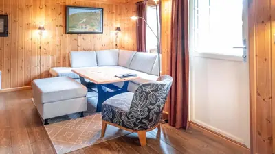 a living room with a table and a chair at Geilolia Hyttetun in Geilo