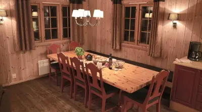 a dining room table with chairs and a wooden tableablish at Geilolia Hyttetun in Geilo
