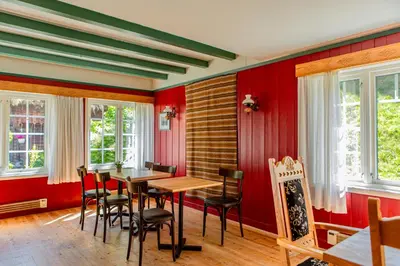 a dining room with red walls and a table and chairs at Ullensvang Gjesteheim in Lofthus