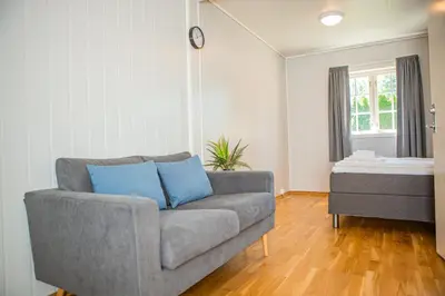 a living room with a couch and a table at Ullensvang Gjesteheim in Lofthus