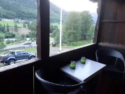 a table and chairs in a room with a window at Teigen Gard in Lom