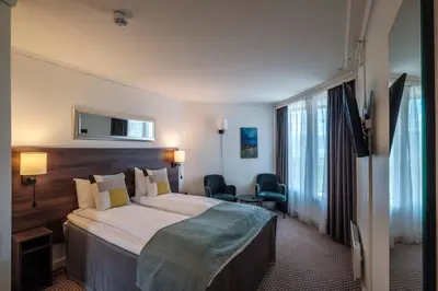 a hotel room with a large bed and a television at Hardangerfjord Hotel in Øystese