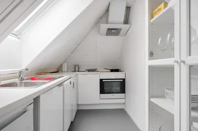a kitchen with white cabinets and a sink at LS Apartments in Bergen