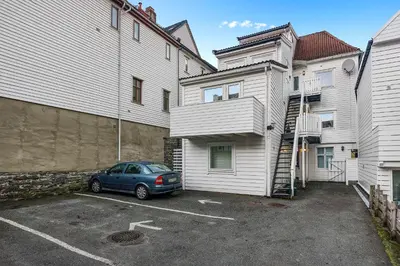 a car parked in a parking lot between two buildings at LS Apartments in Bergen