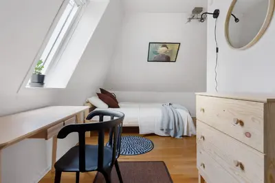 a bedroom with a bed and a desk with a chair at LS Apartments in Bergen