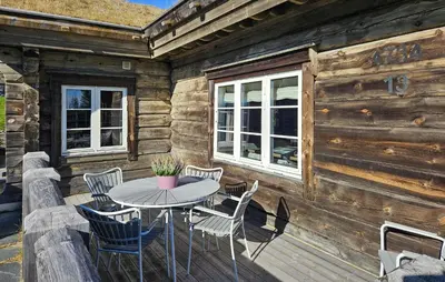 a wooden cabin with a table and chairs on a deck at Amazing Home In Sjusjøen With Sauna in Sjusjøen