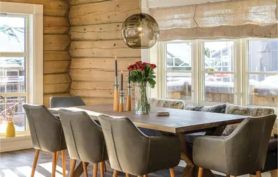 a dining room with a wooden table and chairs at Amazing Home In Sjusjøen With Sauna in Sjusjøen