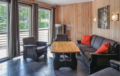 a living room with a couch and a table and chairs at Cozy Apartment In Hemsedal With Sauna in Hemsedal