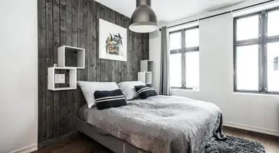 a bedroom with a bed with a wooden wall at Neumannsgate 4 in Bergen