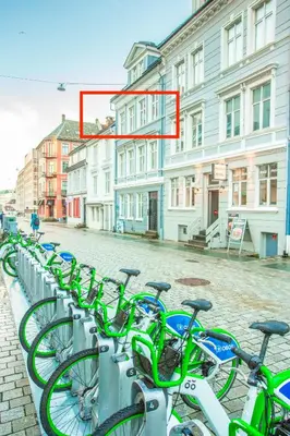 a row of bikes parked on a street at Neumannsgate 4 in Bergen