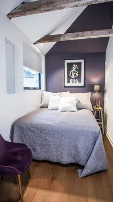 a bedroom with a large bed with a purple wall at Neumannsgate 4 in Bergen