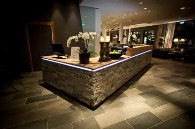a lobby with a stone counter with flowers on it at Quality Hotel Skifer in Oppdal