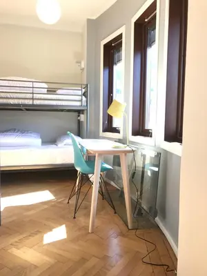 a room with a desk and a bed and a table and chairs at City Hostel Bergen in Bergen