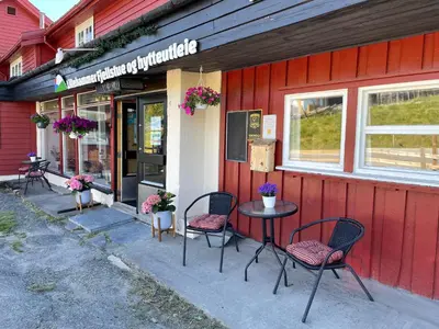 a red building with chairs and a table outside at Lillehammer Fjellstue og Hytteutleie in Nordseter