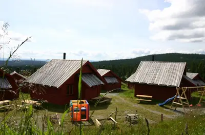 a group of huts in a field with trees at Lillehammer Fjellstue og Hytteutleie in Nordseter