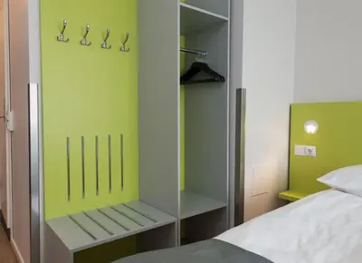 a bedroom with a bed and a green wall at Thon Hotel Trondheim in Trondheim